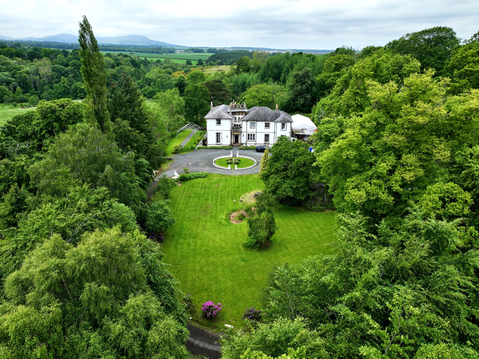 The Mansion at Kirkhill set among trees and lawn.